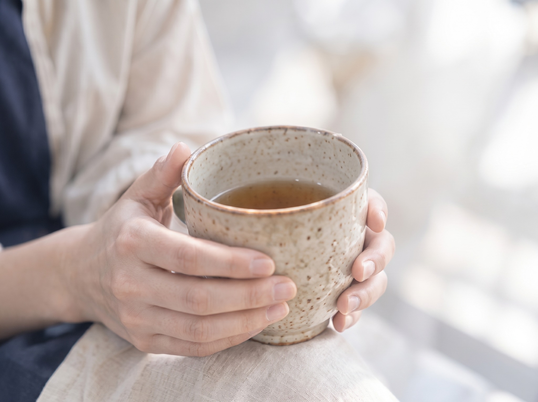 両手でマグカップを持つ様子